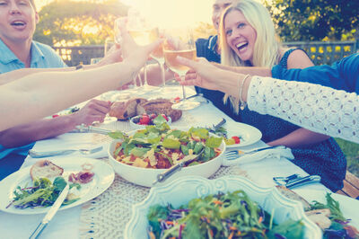 Friends enjoy a shared cheers to good times and great wine with Grand Banker white wine and a fresh backyard BBQ.